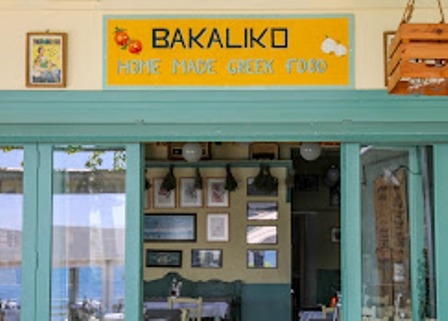 Front of a Greek restaurant named Bakaliko with a yellow sign reading 'BAKALIKO Home Made Greek Food' and turquoise storefront framing the windows and doors.