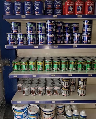 Store shelf full of paint cans in blue, green, and white packaging on a hardware store display.
