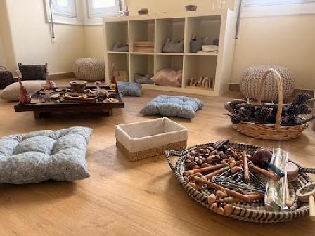 Sensory room or cozy play space with floor cushions, baskets of natural materials, and a low table on a wooden floor