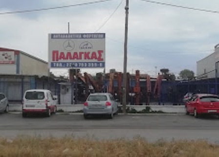 Exterior view of a Greek auto shop with a large sign reading 'ΠΑΛΑΓΚΑΣ' and several cars parked in front.